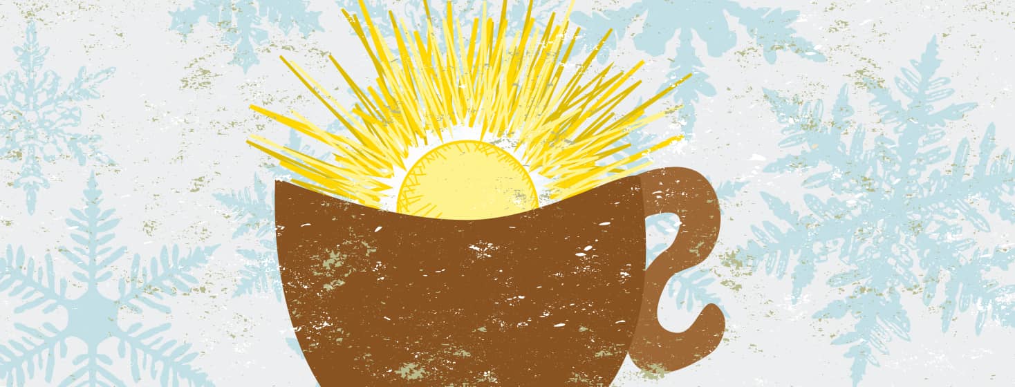 A mug full of warm sunshine sits in front of a snowflake background