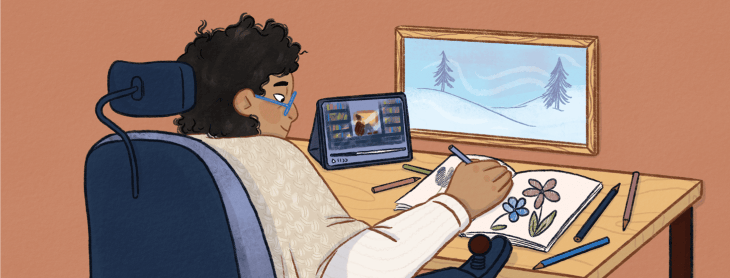 A person in a wheelchair colors on a desk and streams content on their tablet in front of a snowy window scene